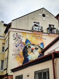 Low angle view of graffiti on building against sky