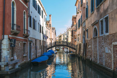 Moored boats in canal along built structures