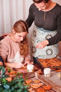 Mother and daughter preparing gingerbread cookies at home