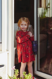 Portrait of cute girl standing by window