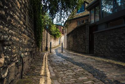 Walkway amidst buildings against sky