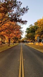 Empty road along trees during autumn