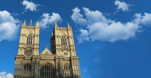 Low angle view of clock tower against blue sky