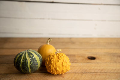 Close-up of pumpkins on table against wall