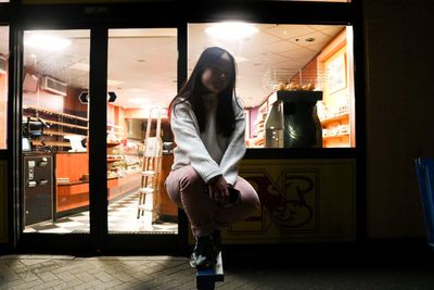 Full length of woman standing in illuminated building