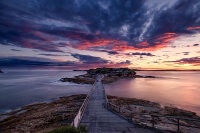 Scenic view of river against cloudy sky