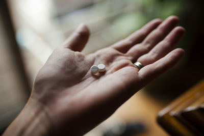 Cropped image of woman with pills in hand