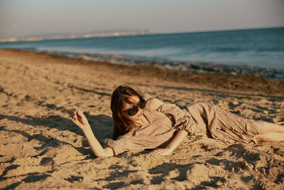 Portrait of young woman sitting at beach