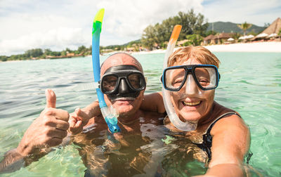 Portrait of smiling couple swimming in sea