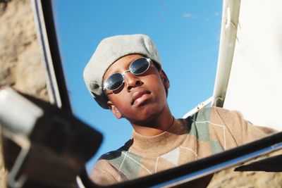 Low angle view of young boy wearing sunglasses chilling and relaxing 