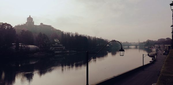 Bridge over river against buildings in city