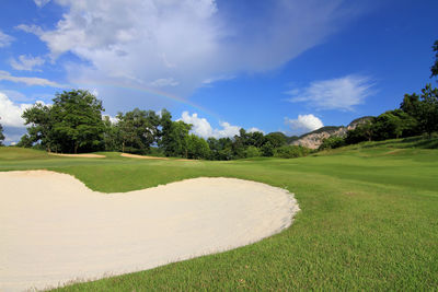 Scenic view of golf course against sky