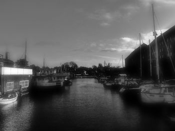 Boats in river against sky in city