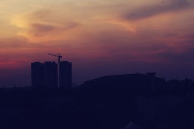 Silhouette buildings against sky during sunset