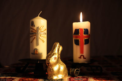 Close-up of easter bunny and illuminated candles on table during christmas