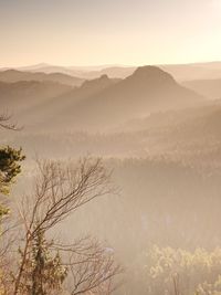 Rocky hill above inverse mist. winter cold weather in mountains colorful fog. misty valley in winter