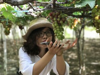 Close-up of young woman holding tree