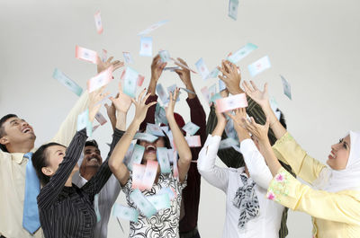 Cheerful business colleagues looking up against white background