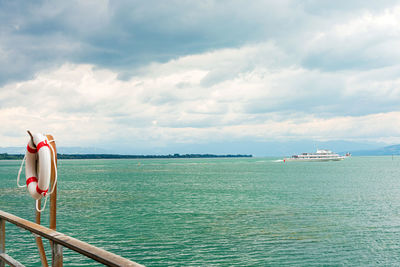 Rear view of woman standing by sea against sky