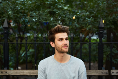 Portrait of young man against trees