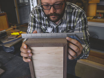 A woodworker measuring out the next detail for the box he is building