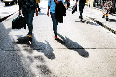 Low section of people walking on city street