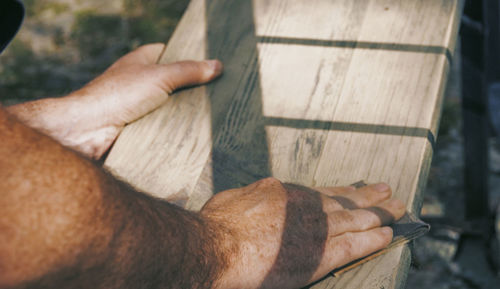 Cropped hands of man sanding wood