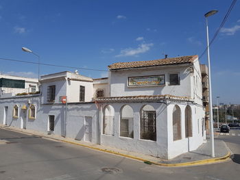 Street by buildings against sky in city