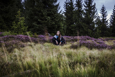 Woman sitting by flowering plants 