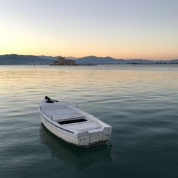 Boat in lake against sky during sunset