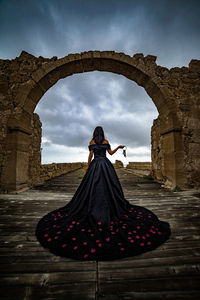 Rear view of woman in dress standing on walkway