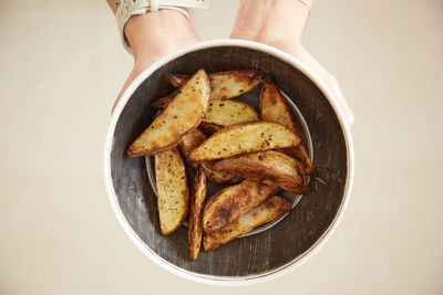 Holding potato fries on a plate background.