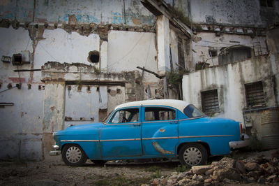 Abandoned car against buildings
