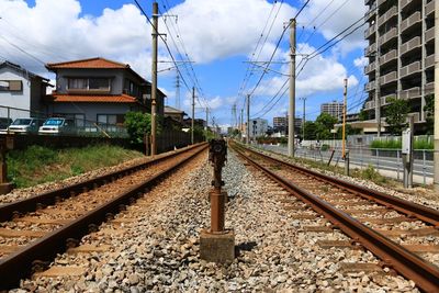 Railroad tracks against cloudy sky