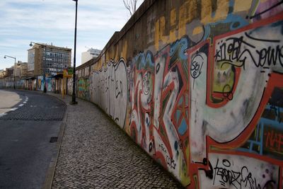 Graffiti on wall in city against sky