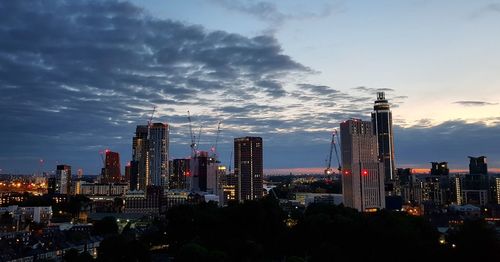 Illuminated modern buildings against sky during sunset