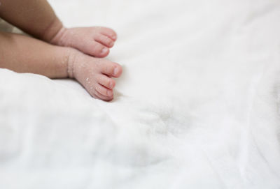 Close-up of baby hand on bed