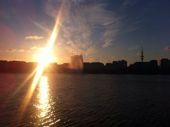 Sun shining through clouds over city