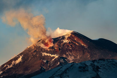 Smoke emitting from volcanic mountain against sky