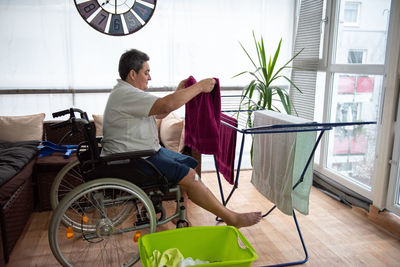 Side view of young woman sitting on wheelchair