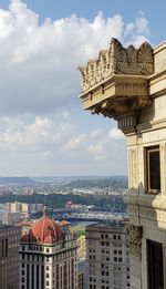 Buildings in city against cloudy sky