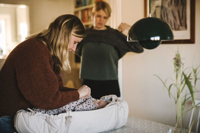 Mothers tucking newborn baby in stroller cot