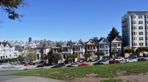 Buildings in city against clear blue sky