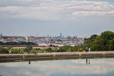 People in park by city against sky
