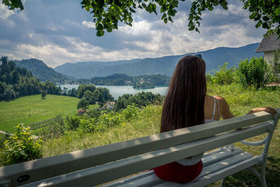 Rear view of woman by railing against mountains