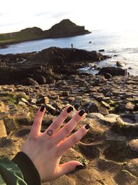 Cropped hand on woman against beach