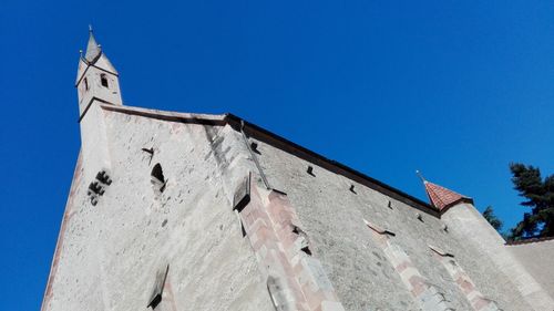 Low angle view of bell tower against blue sky