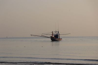 Sailboat in sea against sky during sunset