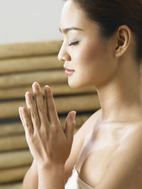 Woman with cross-legged meditating indoors