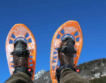 Woman snowshoeing against clear blue sky